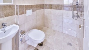 A bathroom with a toilet, sink, and shower. - Kaya Apart  (Kas)