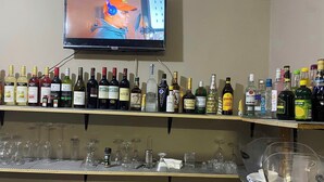A bar area with shelves of liquor bottles and glasses. - Dikukama Hotel (Tshabong)