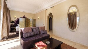 A room with a sofa, a coffee table with a book, a mirror, and a lamp. - Luxury villa with swimming pool, not overlooked. (Marrakech)