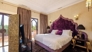 A bedroom with a large bed, a TV, a nightstand, and a view of the outdoors. - Luxury villa with swimming pool, not overlooked. (Marrakech)