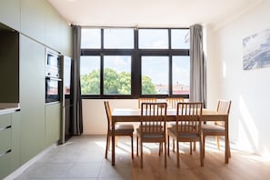 Una cocina moderna con comedor, ventanas amplias y vista a zonas verdes.