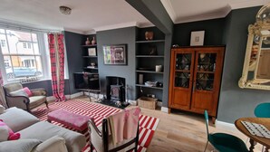 Ein gemütliches Wohnzimmer mit Kamin, Fernseher und Bücherregal.