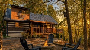 A rustic cabin with a wooden deck, a fire pit, and two chairs. - Sneaky Bear Getaway, Hot Tub, WIFI,  $560 FREE tickets each paid day!!! (Sevierville)