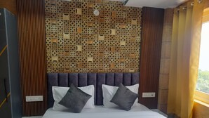 A neatly made bed with white linens and two pillows, a wooden headboard, and a decorative wall panel. - Hotel Asha Delight (Narendranagar)