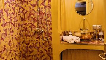 A bathroom with a shower, a sink with a mirror, and a towel rack.