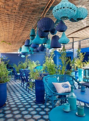 An outdoor seating area with blue furniture and hanging lamps. - Riad & Spa Stella Cadente (Marrakech)