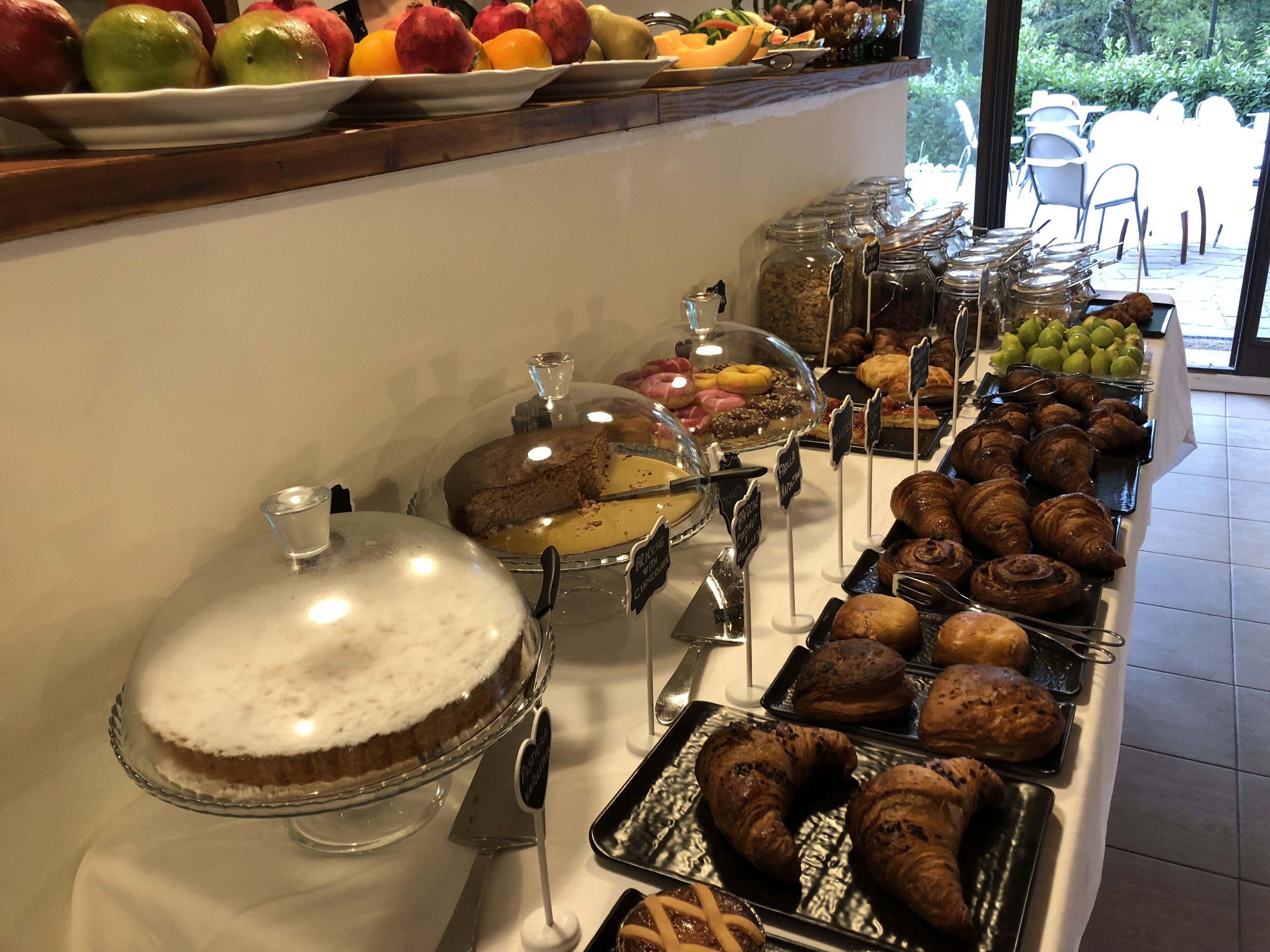 A buffet with various food items including pastries, fruits, and desserts.