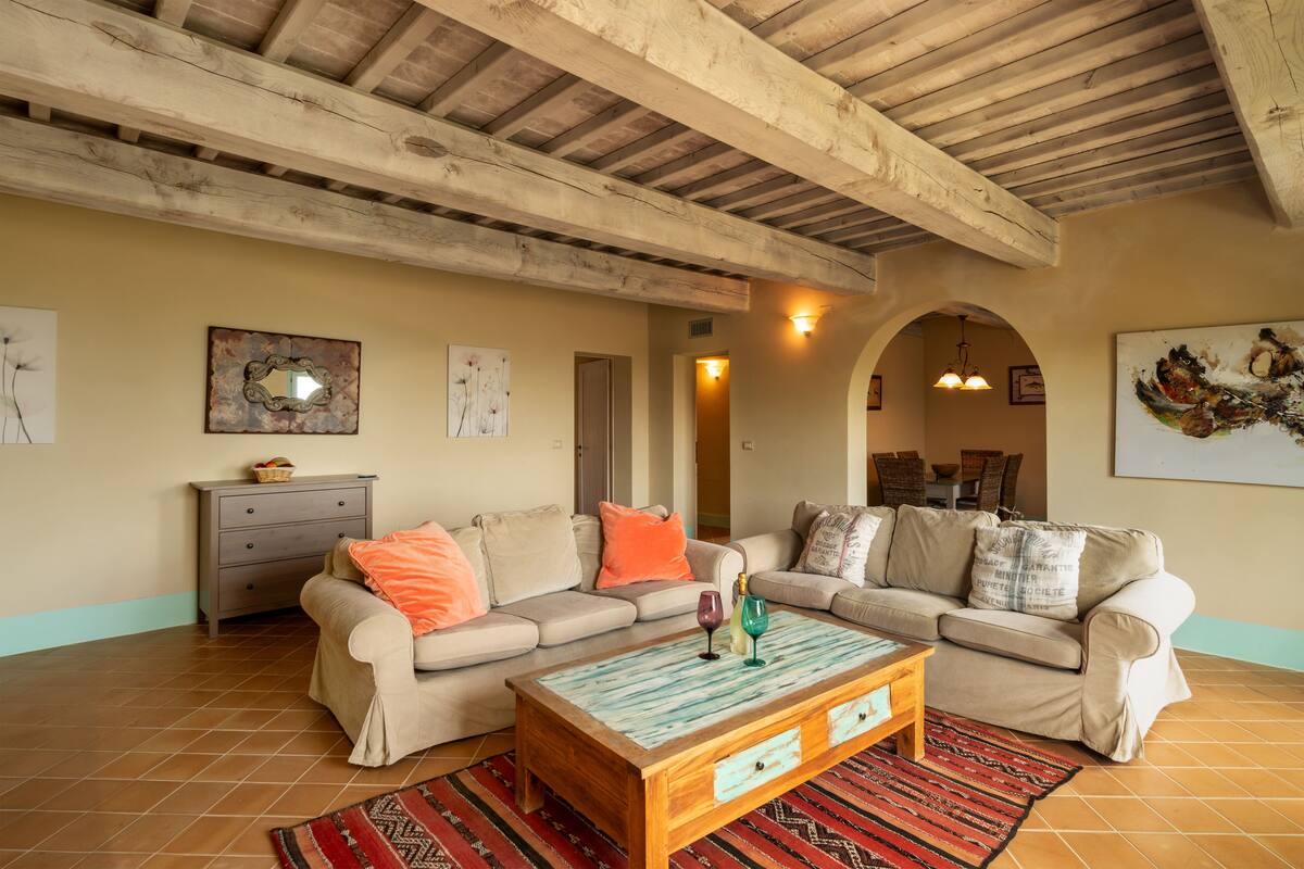 A living room with two beige sofas, a wooden coffee table, and a patterned rug.