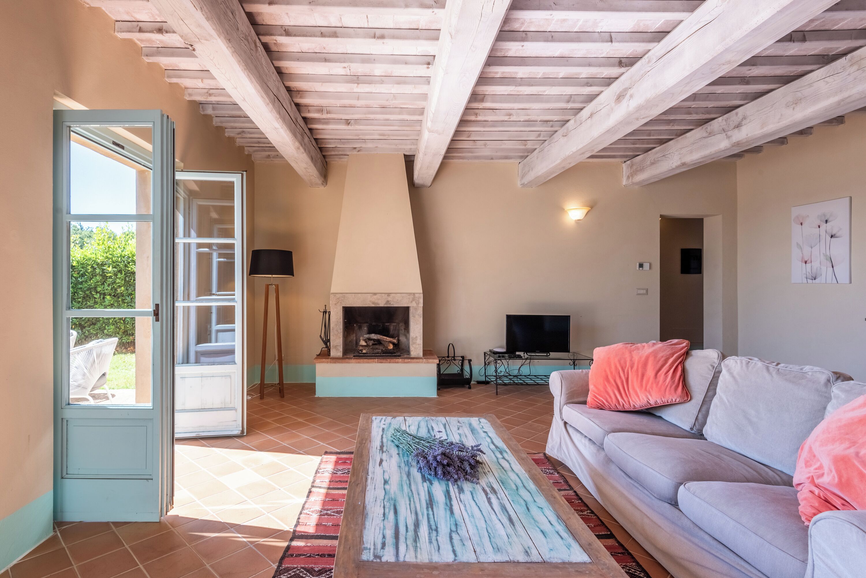 Un salon comprenant un canapé, une cheminée, un téléviseur et une porte donnant sur un espace extérieur.