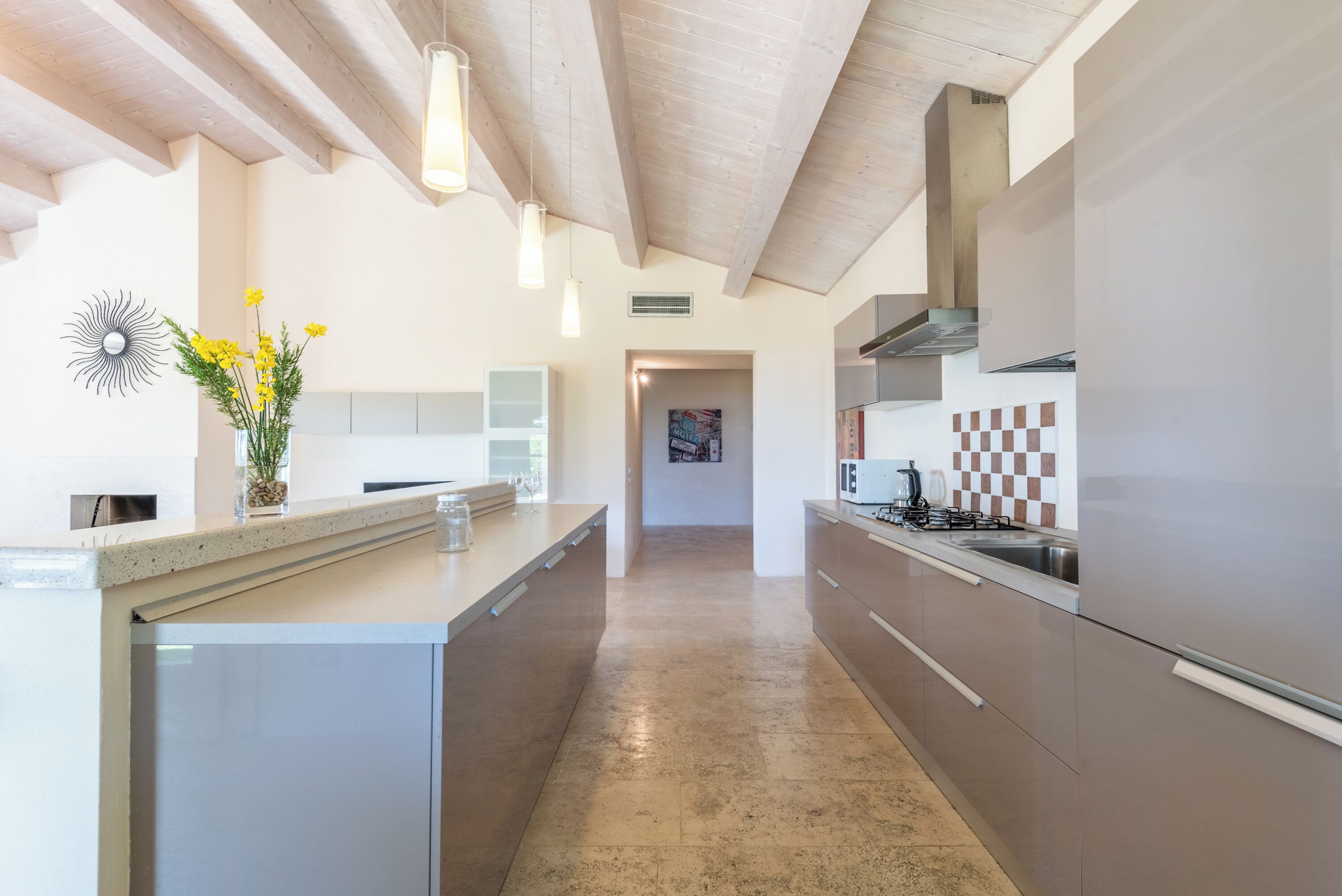A modern kitchen with a central island, stainless steel appliances, and a view to the dining area.