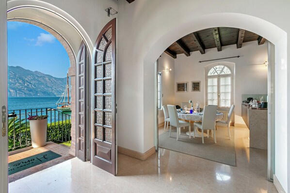 Un intérieur moderne comprenant un coin repas, une cuisine et un balcon avec vue sur la mer.