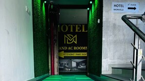 Entrada de un hotel con un cartel que indica el tercer piso y habitaciones.