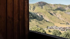 Vista de un valle con un pueblo pequeño y montañas al fondo.
