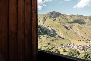 Μια θέα μιας κοιλάδας με μια μικρή πόλη και βουνά στο βάθος.