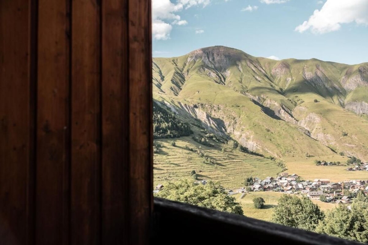 Une vue sur une vallée avec une petite ville et des montagnes en arrière-plan.