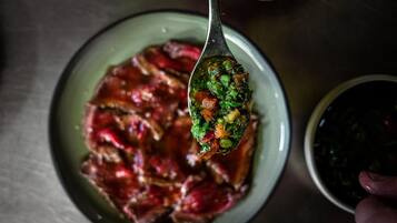 A spoonful of food being held over a plate.