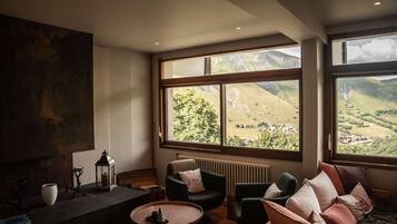 A modern living room with large windows, a fireplace, and comfortable seating.