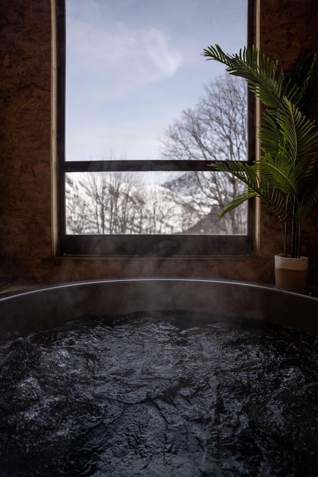 A steam bath with a view of bare trees outside through a window.