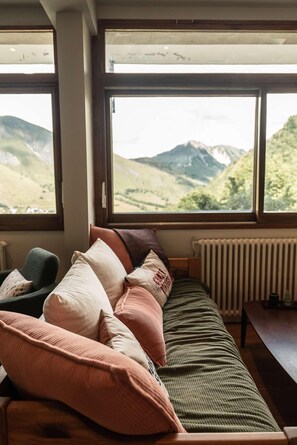 A cozy room with a sofa and chairs facing large windows overlooking a mountainous landscape. - Les Cedres - Hotel, Restaurant & Spa (Saint-Sorlin-d'Arves)