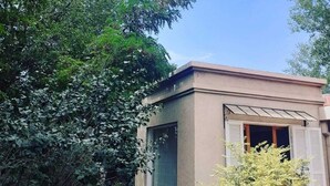 Un edificio con techo plano, un ventanal y una puerta.
