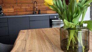Un tavolo di legno con un vaso di tulipani gialli in un recipiente di vetro.