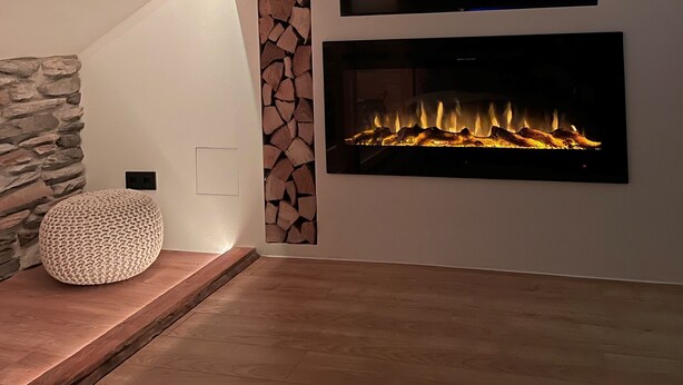 Un soggiorno moderno con una parete a pietra decorativa, un camino e un televisore a schermo piatto montato sopra.