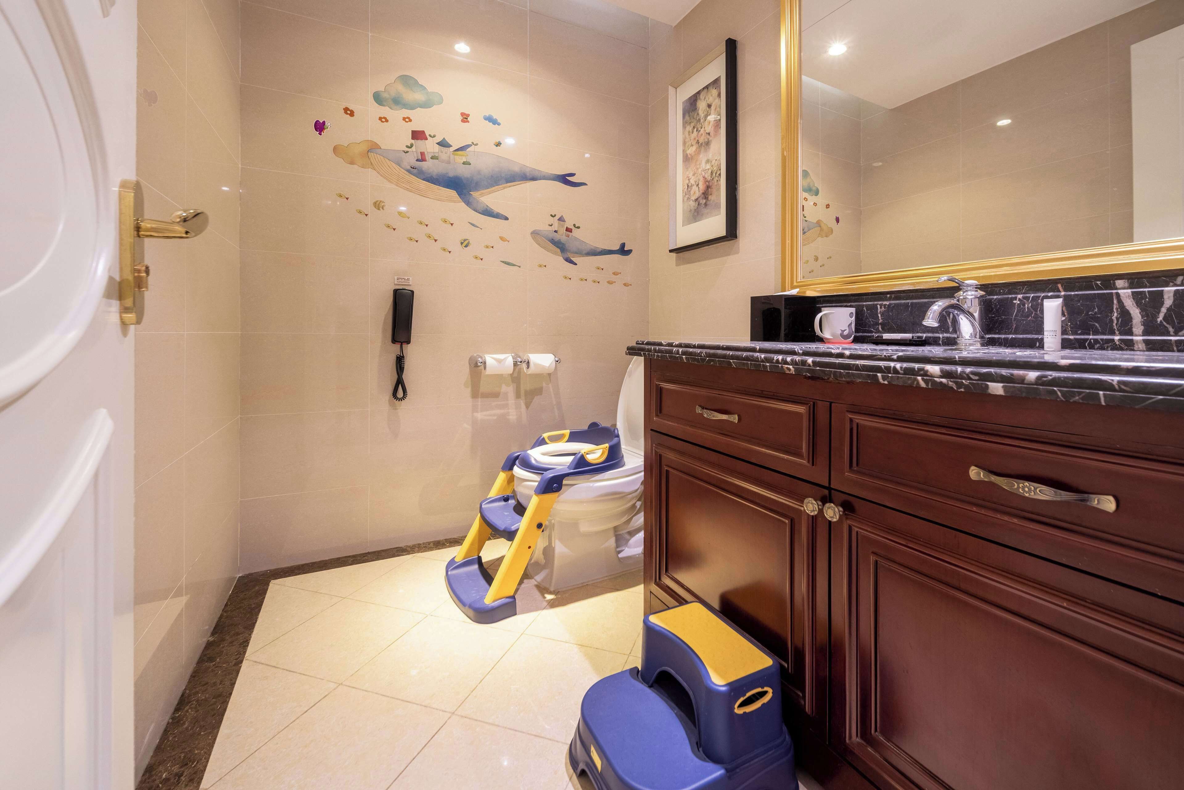 A bathroom with a toilet, a shower, a sink, and a mirror.