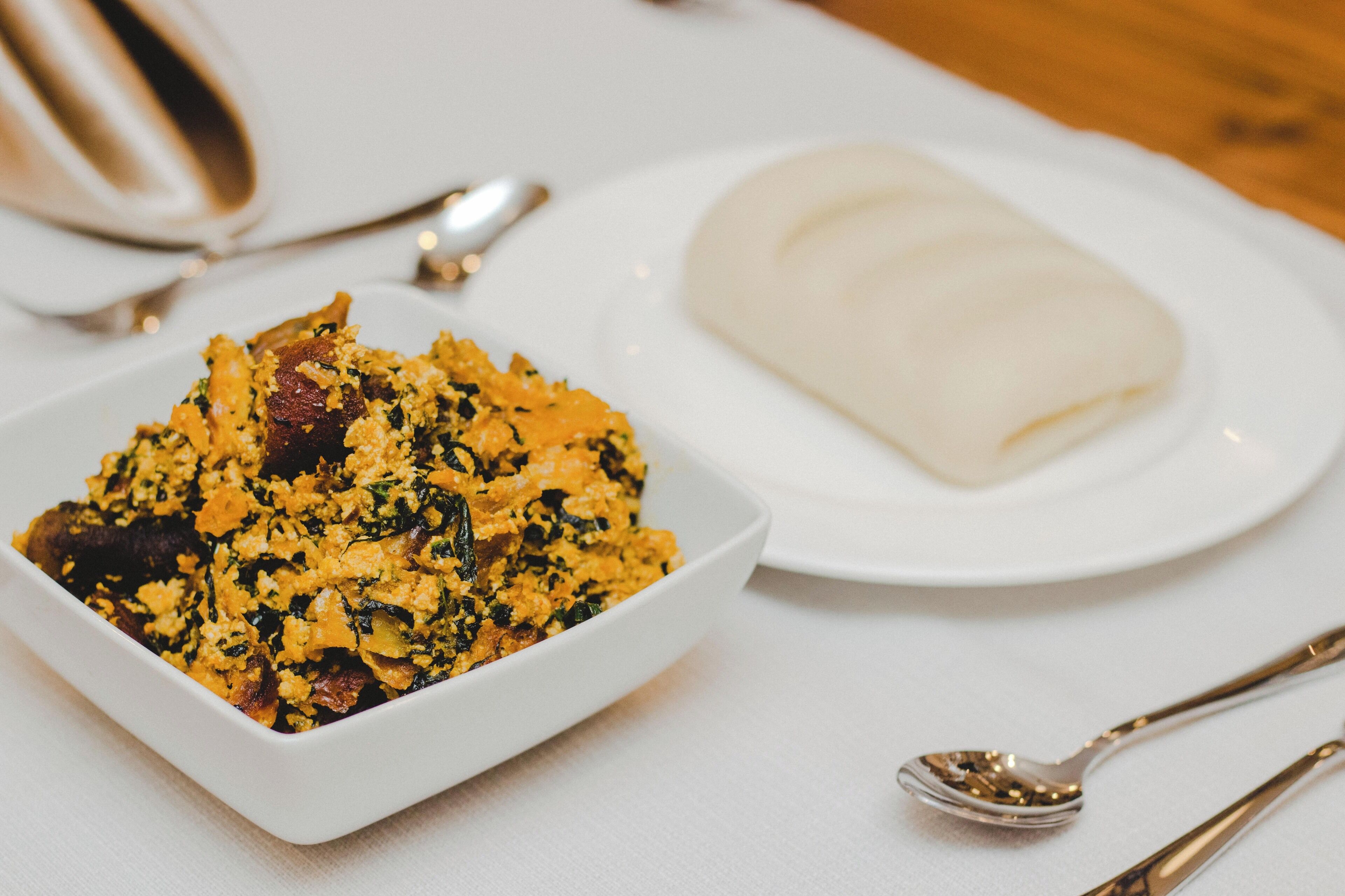 A white plate with a food dish and a white plate with a white food item.