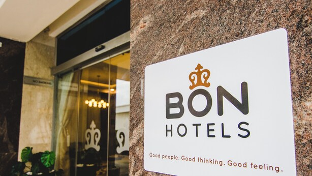 A sign for BON HOTELS with a crown logo and the text "Good people. Good thinking. Good feeling." - Bon Hotel Imperial (Abuja)