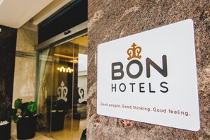 A sign for BON HOTELS with a crown logo and the text "Good people. Good thinking. Good feeling." - Bon Hotel Imperial (Abuja)