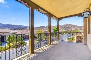 Un balcone con vista su una zona residenziale e montagne.