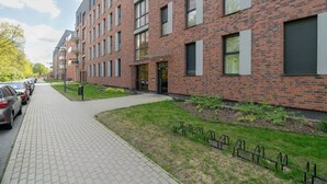 A modern brick building with multiple windows and a paved walkway.