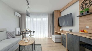 Een moderne woonkamer met een bank, salontafel en een eethoek.