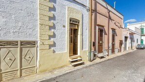 A street view with a building featuring a white facade, a door with steps leading up to it, and a bench outside. - 3836 Da Donatuccia by Barbarhouse (Presicce-Acquarica)