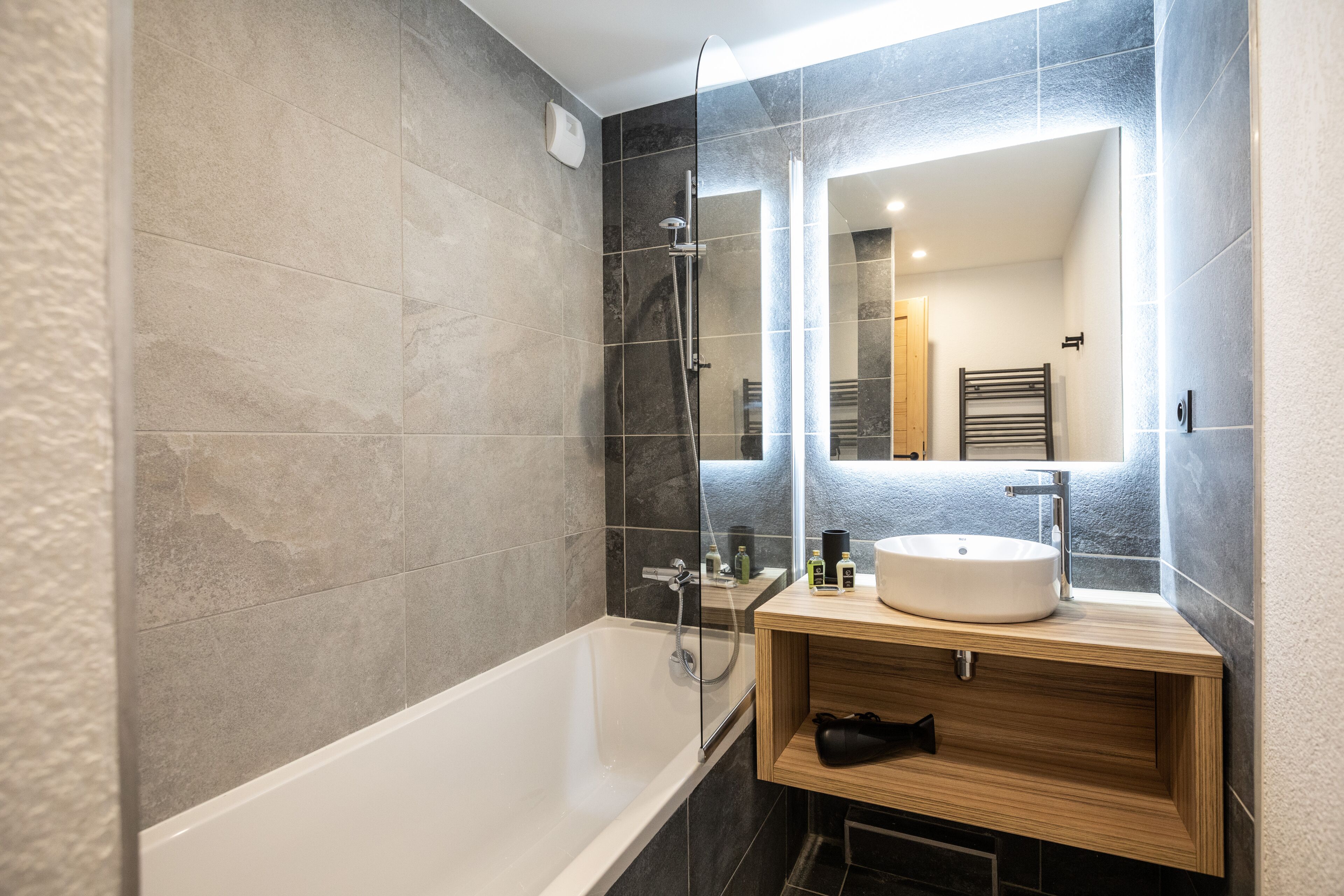 Un bagno moderno con una vasca, un lavandino e uno specchio.