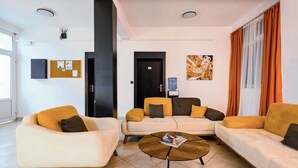 Una sala de estar moderna con dos sofás, una mesa de centro y un tablón de anuncios.