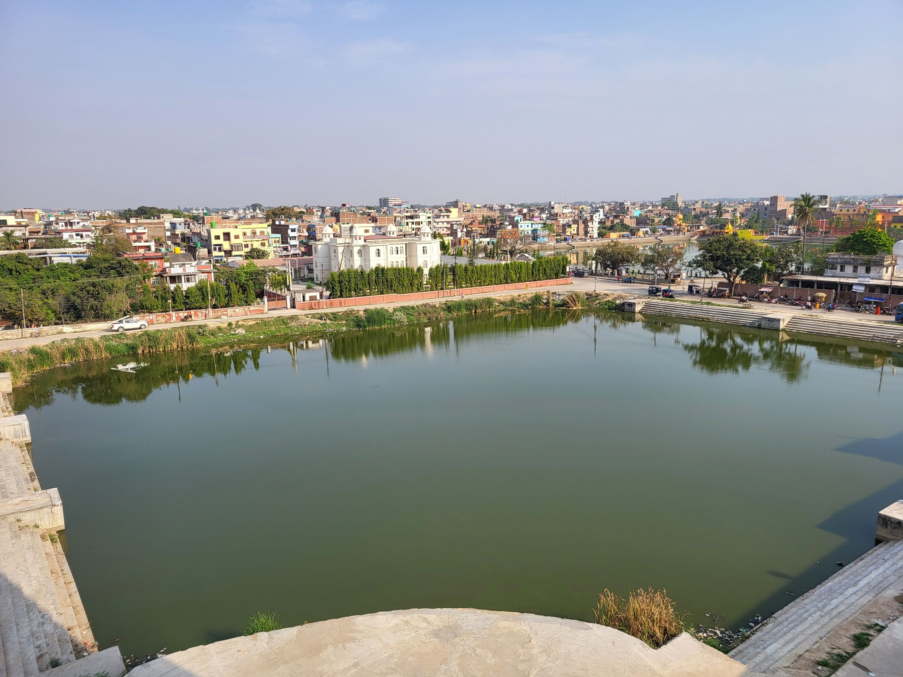 A large, calm water body surrounded by buildings and greenery.