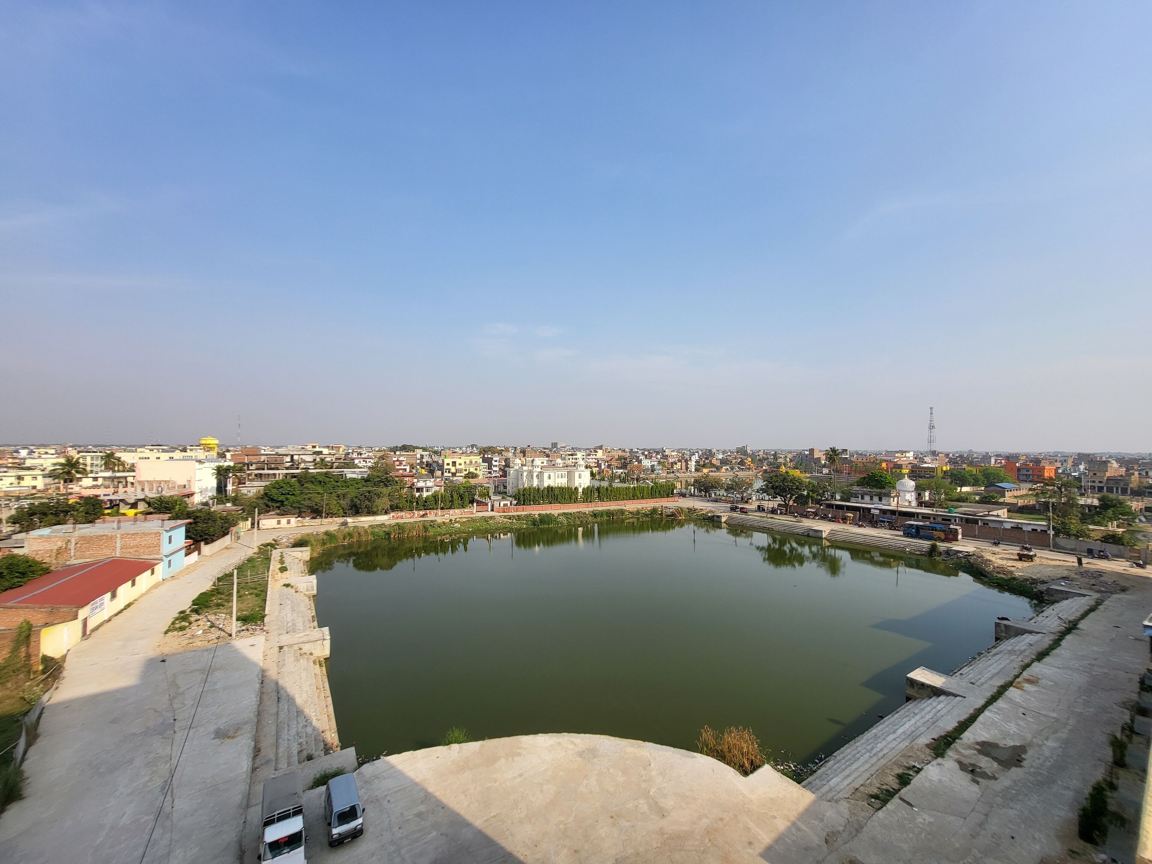A large body of water with a bridge and a road leading to a building with a dome.