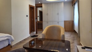 A modern room with a wooden cabinet, a dining table, and a sofa. - Anjani Suite (Janakpur)