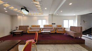 A spacious lobby with a marble floor, a reception desk, and a staircase leading to upper floors. - Anjani Suite (Janakpur)
