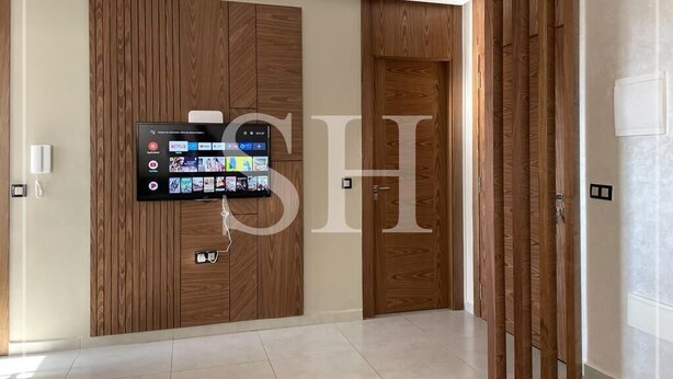 A modern interior with a mounted TV displaying various streaming services, wooden panel walls, and a sliding door.