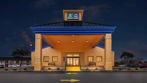 L’entrée d’un hôtel, reconnaissable à son toit bleu et à une enseigne indiquant qu’il s’agit d’un hôtel « Quality Suburban ».