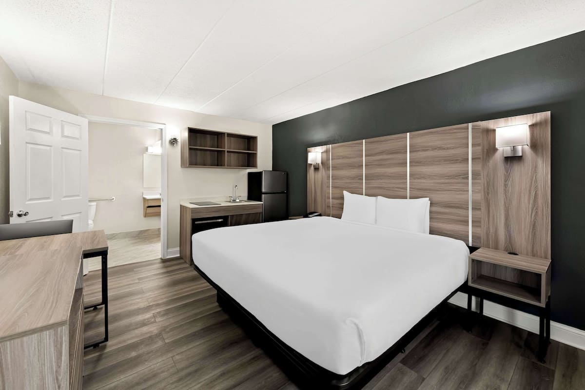 Une chambre d’hôtel moderne, dotée d’un grand lit, d’un bureau et d’une coiffeuse.