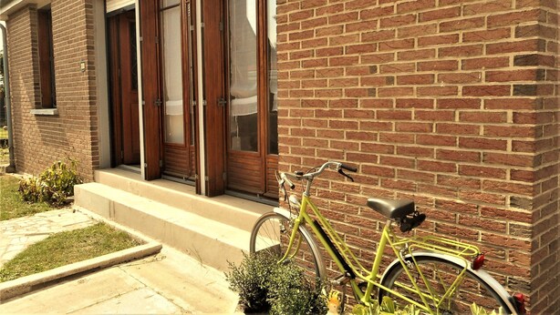 A brick building with a green bicycle parked outside.