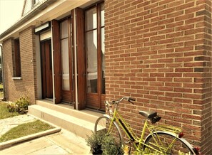 Un edificio de ladrillo con una bicicleta verde estacionada afuera.