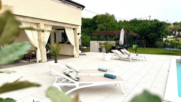 A poolside area with lounge chairs and a pergola. - 10 minutes from the sea, a newly renovated appartment for 6 person
 (labin)