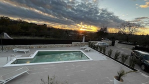 A rectangular pool with a stone border, surrounded by lounge chairs and potted plants. - 10 minutes from the sea, a newly renovated appartment for 6 person
 (labin)