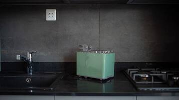Eine Küche mit Spüle, einem grünen Toaster und einem Herd.