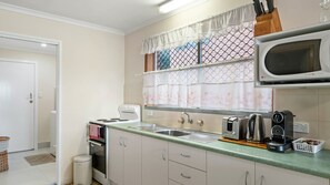 Fridge, microwave, oven, stovetop - Retro 1BR riverfront apartment with backyard, BBQ, and easy access to water activities (Evans Head)