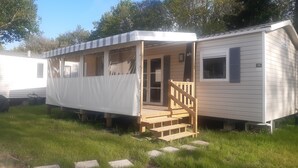 A mobile home with a porch and a staircase leading to the entrance.